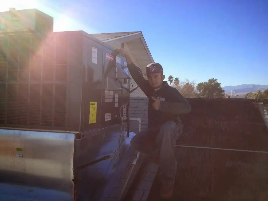 HVAC technician performing AC Tune-Up on a rooftop unit in Margate